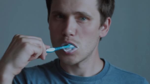 Un joven se cepilla los dientes. — Vídeo de stock