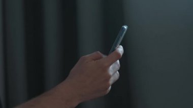 Evde akıllı telefon kullanan adamın elleri.