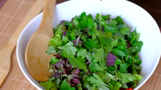 Köchin gießt Olivenöl auf veganen Salat. — Stockvideo