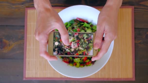 Weibliche Hände fotografieren vegetarisches Essen mit dem Smartphone. — Stockvideo