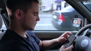 Avrupalı adam akıllı telefon kullanıyor, arabada oturuyor.