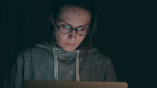 Брюнетка дівчина працює над ноутбук в ніч на дому. — стокове відео