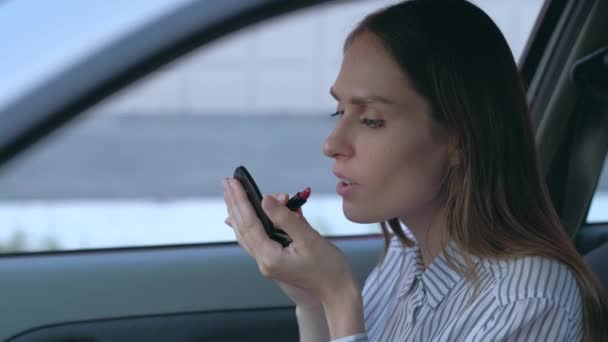 Frau schminkt sich im Auto. — Stockvideo