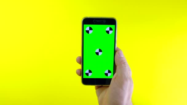 Mann benutzt Smartphone mit grünem Hintergrund. — Stockvideo
