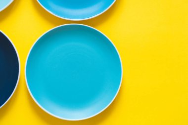 Sarı arka planda izole renkli pastel mavi seramik plakalar.