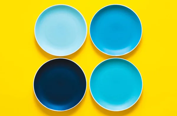 Sarı arka planda izole renkli pastel mavi seramik plakalar.