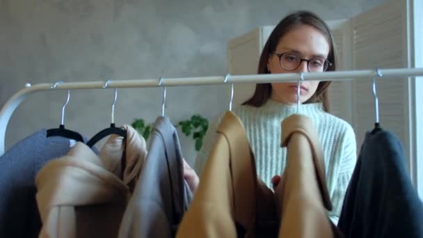 Belle femme en lunettes choisit des vêtements pour une réunion d'affaires . — Video