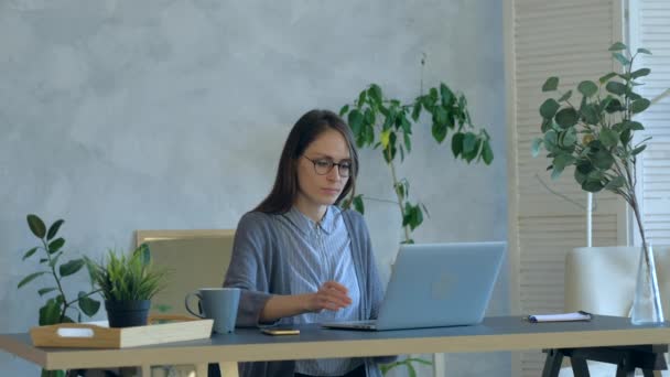 Наголошена молода жінка роздратована використанням зламаного ноутбука в офісі . — стокове відео