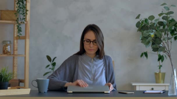 Kvinna på kontoret öppna laptop och glad överraskad av goda nyheter online. — Stockvideo