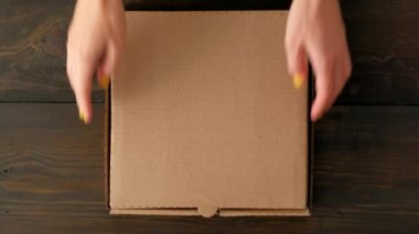 Ahşap arka planda donutlu Kadın Elleri Kutusu.