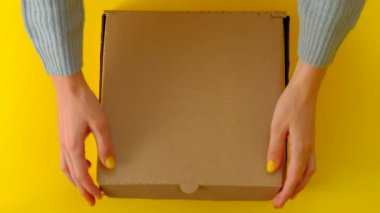 Kadın Elleri Sarı arkaplanda Donutlu Kutuyu Aç ve Kapat.