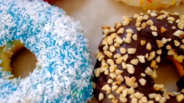 Tracking shot gekleurde verse donuts in doos. — Stockvideo