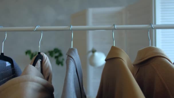 Femme choisissant des vêtements de manteau pendant les achats ou être dans la penderie à la maison . — Video