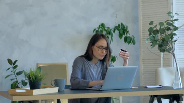 Femme achetant des achats en ligne par carte à l'intérieur, en utilisant un ordinateur portable à l'heure du jour . — Video