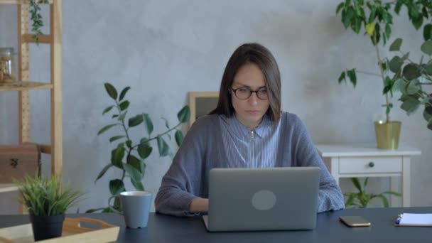 Beautiful woman in eyeglasses work on laptop in office. Medium shoot. — ストック動画