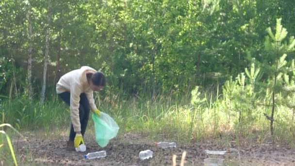 Volontär samlar plastflaskor utomhus. — Stockvideo