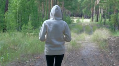 Kadın ormana şişe fırlatıyor.