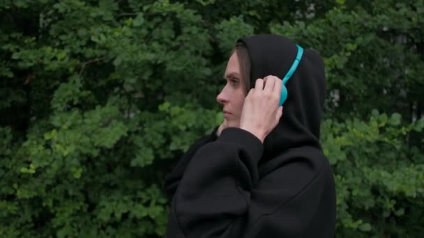 Kobieta wkłada kolorowe słuchawki i tańczy — Wideo stockowe
