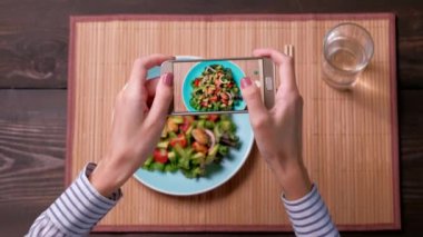 Blogcu, deniz ürünleri ve avokadoyla taze bir salata fotoğrafı çekiyor..