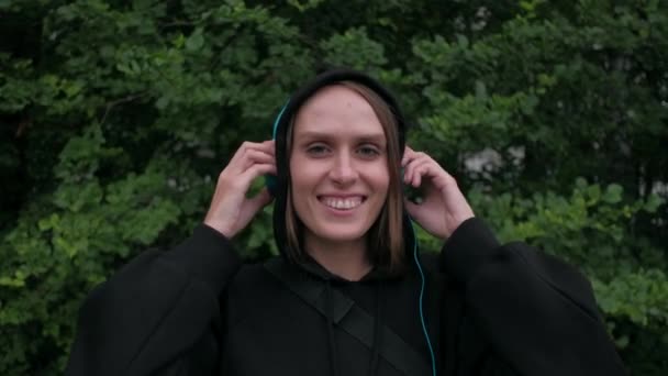 Atraktivní žena poslouchat hudbu v modré sluchátka — Stock video