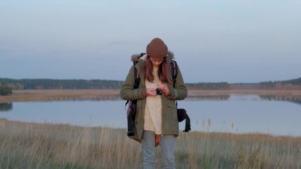 Ung kvinna i skogen använder kompass för navigering. — Stockvideo