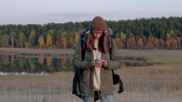 Mujer joven en el bosque tratando de captar una señal móvil. — Vídeo de stock