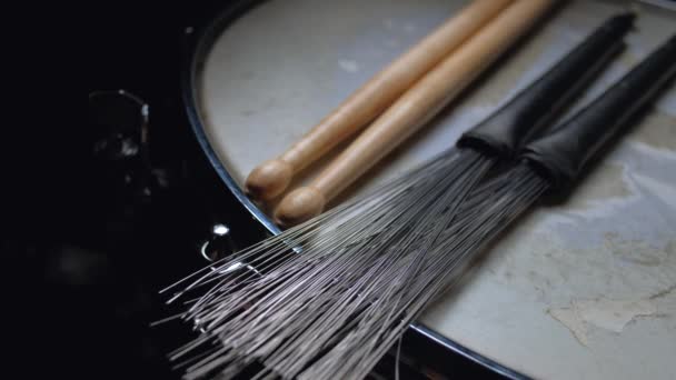 Drumstick and brushes lying on a drum snare close up. — Stock Video