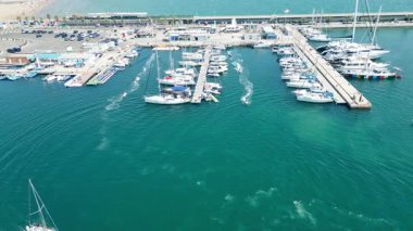 Marina Valencia 'nın çarpıcı hava görüntüsü demirli yatlar, yelkenli tekneler ve canlı şehir silueti. Valencia, İspanya - 2 Ağustos 2025.