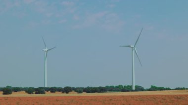 Rüzgâr türbinleri açık kırsal alanda çoklu yel değirmenleriyle dönüyor..
