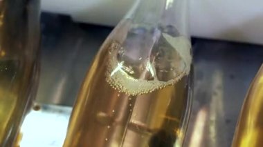 Şampanya şişesi köpüklü meyve şarabıyla dolduruluyor..