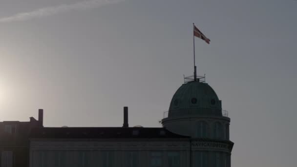 La bandera danesa Dannebrog ondeando en el viento en la parte superior de un edificio — Vídeo de stock