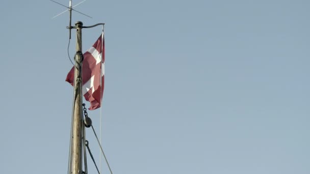 La bandera danesa Dannebrog en la parte superior del mástil de un velero clásico. — Vídeo de stock