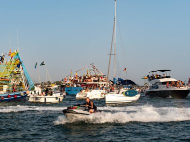 Punta Umbria, İspanya 08.15.2025 Carmen Bakiresi ile bir tekne tarafından taşınan ve diğer teknelerle çevrelenen deniz piyadesi Meryem, denizcilerin ve balıkçıların koruyucusudur.