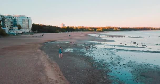 驚くほどのビーチと青い海。美しい少女は、人生を楽しみます。夏休み。水平方向の表示。風景の背景に若い女性は。フィンランド湾。バルト海。観光客の旅のコンセプト. — ストック動画