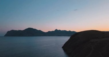 Dağlar tepeler, gün batımı ve deniz. Epik kayalar ve güneş dağ Vadi kenarında flare. 4 k drone uçuş. Hava ıldız. Europe yeşil doğa. Film vintage renkleri.