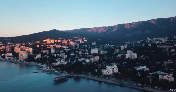 Hegyek csúcsai, naplemente tengerre és a városra. Epic szélén a hegyi völgyben, a sziklák és a sun a fényfolt. 4 k drone repülés. Légi alapító, Sudak. Európa zöld természet. Film vintage színek. — Stock videók