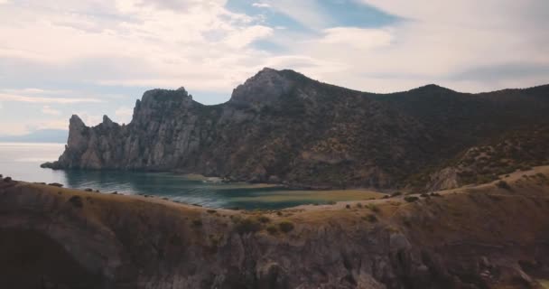 Toppen van de bergen en zee. Epic aan de rand van de vallei van de berg met rotsen en zon flare. 4 k drone vlucht. Luchtfoto stichter. horizontale weergave. Europa groene natuur. Film vintage kleuren. — Stockvideo