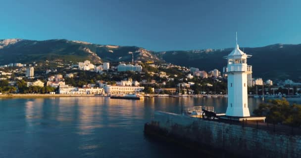 Phare pour les navires et lever de soleil sur la mer. Épopée au bord de la vallée de montagne. Éclair de soleil. Vol de drone 4k. Établissement aérien. Ville au bord de l'océan. Concept de voyage maritime. Film couleurs vintage — Video