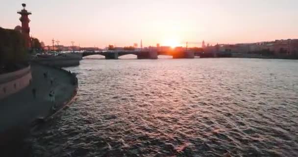 Vue aérienne du coucher du soleil sur la rivière Neva et les colonnes rostrales à Saint-Pétersbourg, en Russie. Vasilievskiy île ville d'en haut, vidéo de drone cinématographique, bâtiments historiques de la capitale du nord — Video
