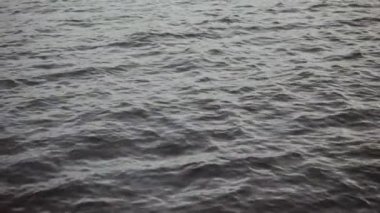 Gri renklerde soğuk deniz. Bulutlu hava. Küçük dalgalar arka plan yakın çekim