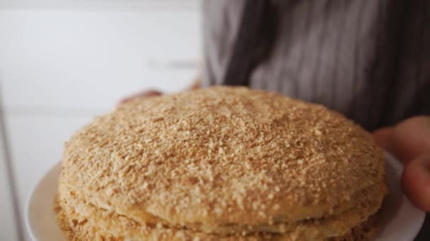 Torta al miele fatta in casa nelle mani. Donna che tiene il cibo dolce sullo sfondo di un grembiule rustico vintage — Video Stock