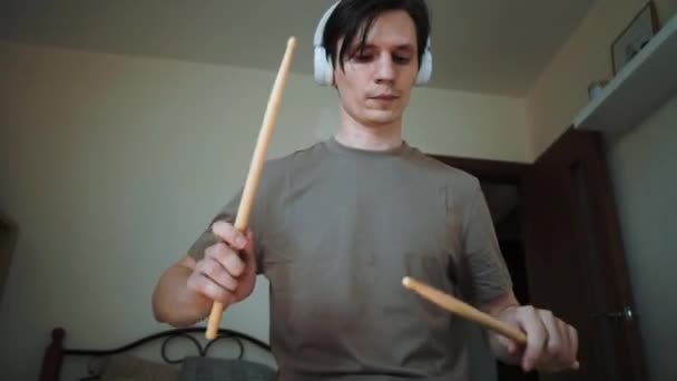 Young drummer exercising with training plastic pad at home. Lessons for percussion instruments with metronome in 60 fps can be in slow motion — Stock Video