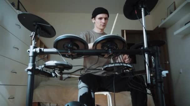 Joven baterista masculino tocando batería electrónica en casa. Actuación de música rock. Instrumentos de percusión lección en 60 fps puede ser en cámara lenta — Vídeo de stock