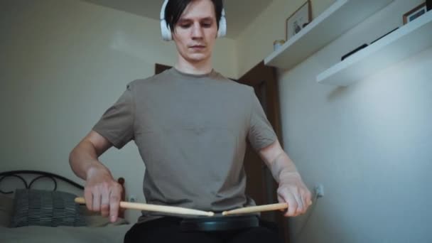 Jonge drummer die thuis traint met het trainen van plastic pad. Lessen voor percussie-instrumenten met metronoom in 60 fps kunnen in slow motion zijn — Stockvideo