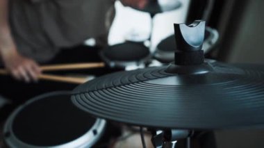 Genç erkek davulcu evde elektronik bateri çalıyor. Rock müzik performansı. Perküsyon aletleri dersi 60 fps yavaş çekimde olabilir