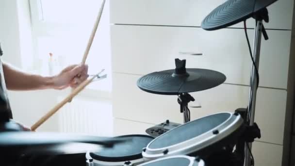 Молодой барабанщик играет дома на электронном барабане. Рок-музыка. Урок ударных инструментов через 60 кадров в секунду может быть в замедленной съемке — стоковое видео