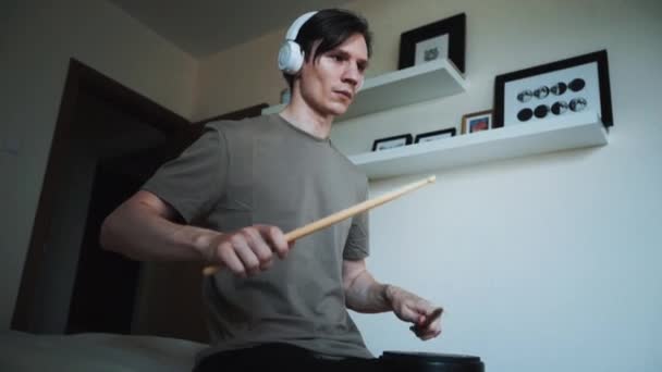 Young drummer exercising with training plastic pad at home. Lessons for percussion instruments with metronome in 60 fps can be in slow motion — Stock Video