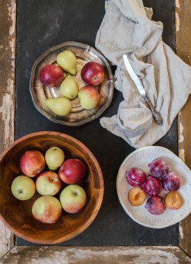 Çeşitli olgunlaşmış meyve - elma, armut ve Erik eski ahşap masa farklı kase. Üstten görünüm. Çiftlik hasat kavramı