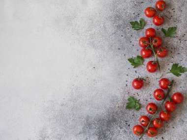 Siyah susam ile gri bir arka plan üzerinde taze kiraz domates. Kopya alanı ile üstten görünüm.
