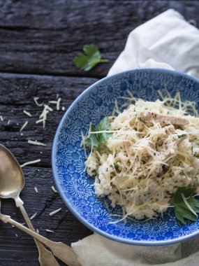 Türkiye ile taze risotto. Risotto ile kanatlı eti ve maydanoz koyu eski ahşap zemin üzerine mavi desenli tabakta. Üstten görünüm